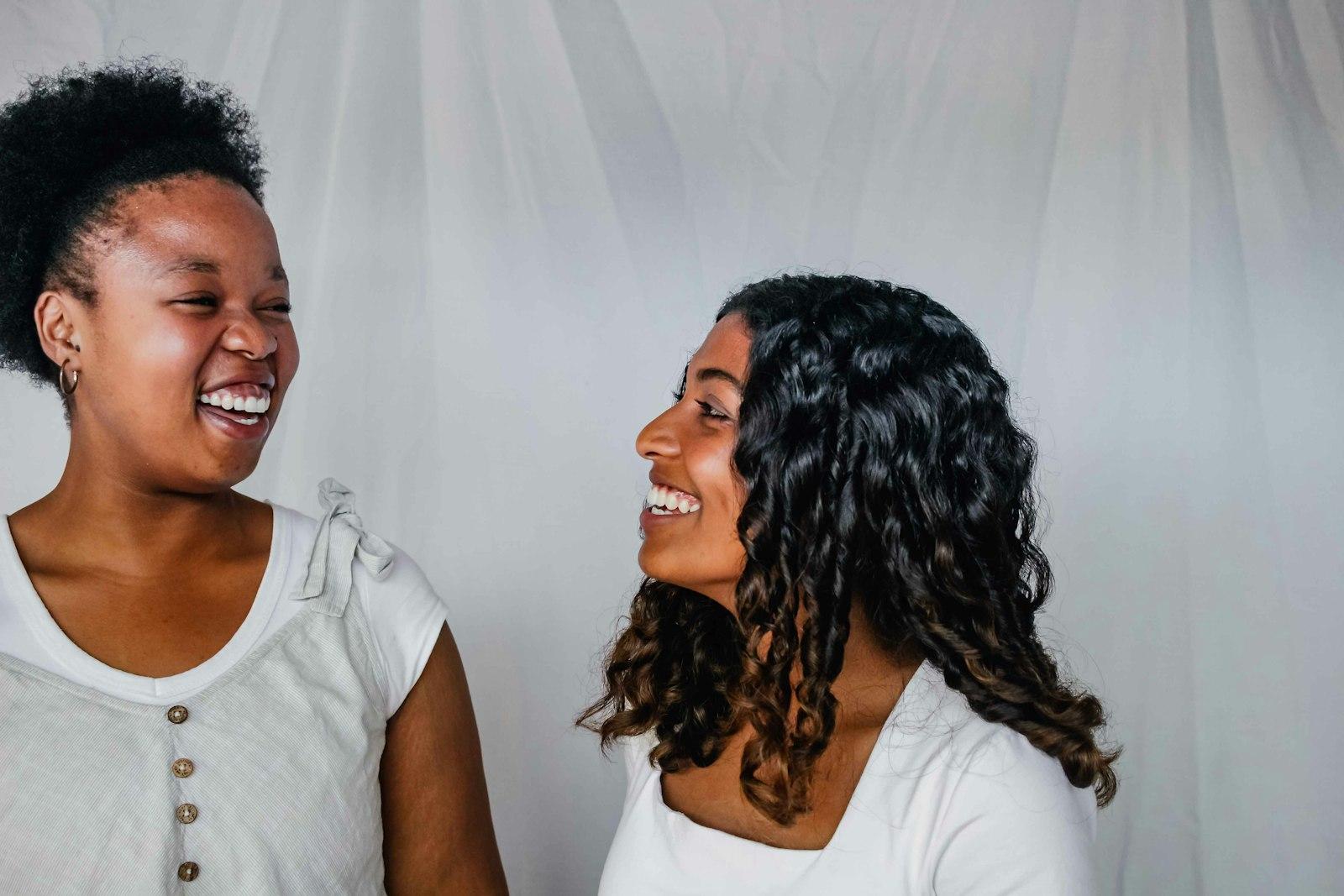 Two women standing together, laughing